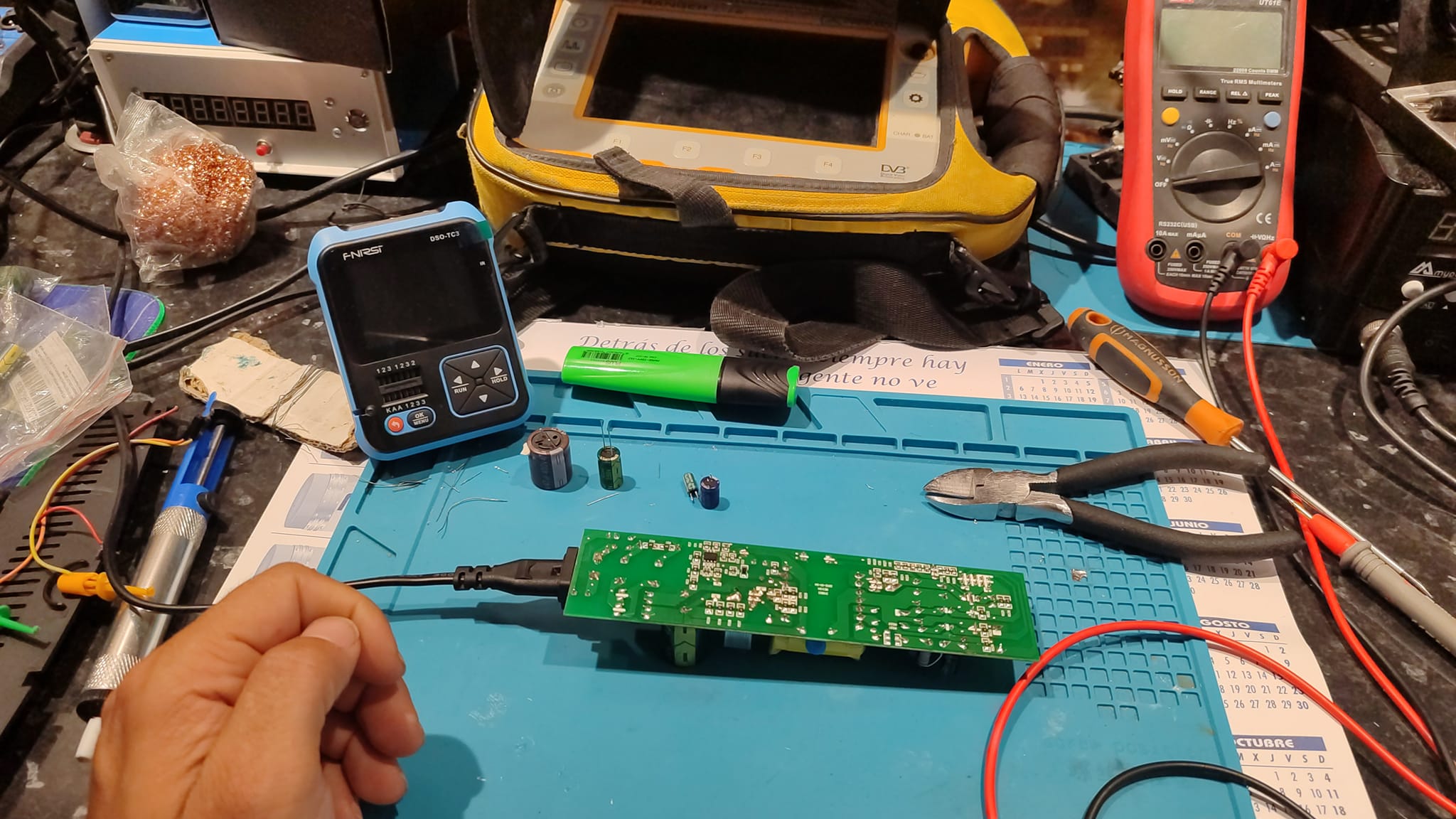 Banco de electrónica con soldador, multímetro y placas en reparación en el taller de Digital Repairs