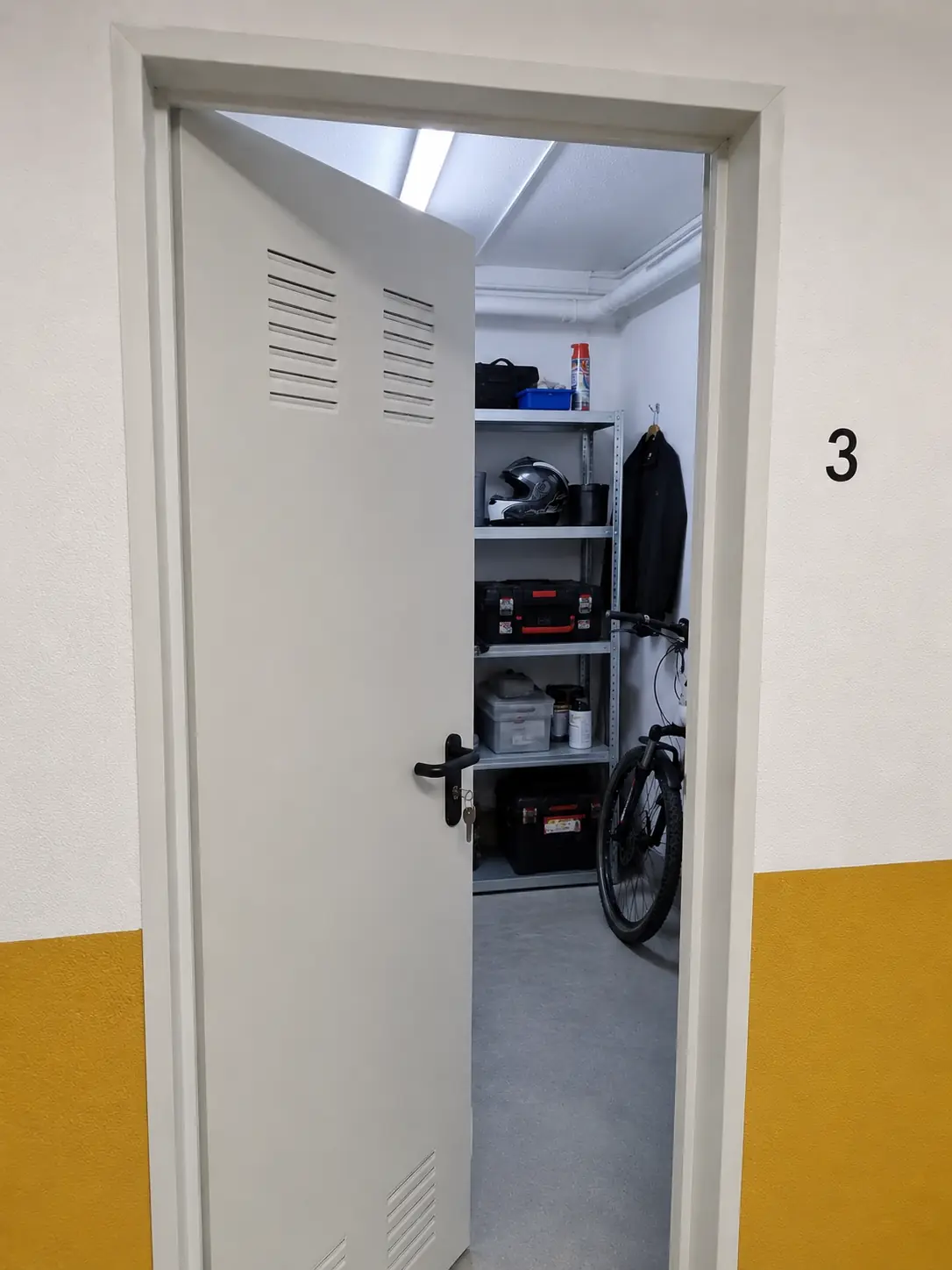 Interior de trastero número 3 con puerta abierta — situación típica de uso del sistema